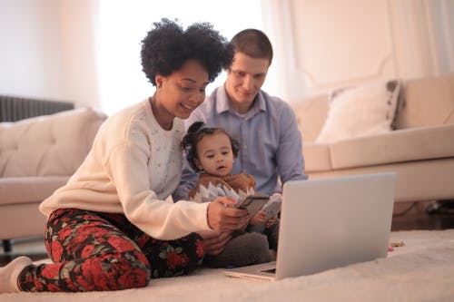 A couple with a toddler looking at a computer