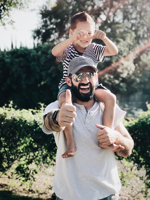 A man carrying a child on his shoulders